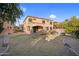 Expansive backyard featuring a manicured lawn, partial fence, and the stucco home in the background at 15635 W Montecito Ave, Goodyear, AZ 85395