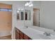 Well-lit bathroom featuring double sinks, wood cabinets, framed mirrors and a separate toilet at 15635 W Montecito Ave, Goodyear, AZ 85395