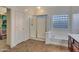 Bathroom showcasing a shower with glass doors, a soaking tub, and tile flooring at 15635 W Montecito Ave, Goodyear, AZ 85395