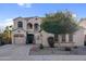 Elegant two-story home featuring arched entryway, gated courtyard, tile roof, desert landscaping and a spacious three-car garage at 15635 W Montecito Ave, Goodyear, AZ 85395