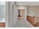 A carpeted upstairs hallway leads to multiple rooms, featuring a staircase and bright natural light at 15635 W Montecito Ave, Goodyear, AZ 85395