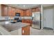 Well-lit kitchen features stainless steel refrigerator and coordinating black microwave and oven at 15635 W Montecito Ave, Goodyear, AZ 85395