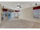 Bright living room features neutral walls, plush carpeting, and a sliding door for easy patio access at 15635 W Montecito Ave, Goodyear, AZ 85395