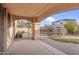 A covered patio with an arched entryway and view of the gated pool area and landscaped backyard at 15635 W Montecito Ave, Goodyear, AZ 85395