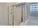 Close-up of shower with glass doors, a tile floor, a tub and a glass block window at 15635 W Montecito Ave, Goodyear, AZ 85395