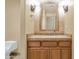 Powder room with wooden vanity, vessel sink, framed mirror, sconces, and tiled accent wall at 15802 N 71St St # 604, Scottsdale, AZ 85254