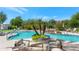 Resort-style pool area with palm trees, a waterfall, comfortable lounge chairs, and lush landscaping at 15802 N 71St St # 604, Scottsdale, AZ 85254