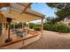 Outdoor patio with a shaded pergola and lush landscaping in the backyard at 16004 W Falcon Ridge Dr, Sun City West, AZ 85375