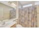 Bathroom featuring a sink, toilet, mirror, shower with curtain, and light fixture at 16004 W Falcon Ridge Dr, Sun City West, AZ 85375