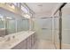 Main bathroom with double sink vanity, large mirror, and glass enclosed shower at 16004 W Falcon Ridge Dr, Sun City West, AZ 85375