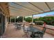 Covered patio with outdoor seating surrounded by lush landscaping in the backyard at 16004 W Falcon Ridge Dr, Sun City West, AZ 85375