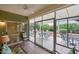 Enclosed sunroom featuring tile floors, ceiling fan, and glass sliding doors to outdoor patio at 16004 W Falcon Ridge Dr, Sun City West, AZ 85375