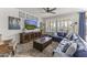 Spacious living room featuring large windows, blue leather couch and wood-look flooring at 175 E Santa Lucia Ln, Queen Creek, AZ 85140