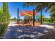 Fun playground area with colorful shades, play equipment, seating, and mature shade trees for community enjoyment at 175 E Santa Lucia Ln, Queen Creek, AZ 85140