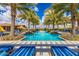 Community swimming pool surrounded by lounge chairs, umbrellas, and palm trees at 175 E Santa Lucia Ln, Queen Creek, AZ 85140