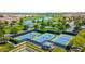 Well-maintained community tennis courts, surrounding greenery, and a view of a neighborhood lake at 175 E Santa Lucia Ln, Queen Creek, AZ 85140