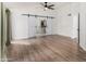 Bedroom with wood floors and a ceiling fan features a barn door leading to the bathroom at 19333 N 68Th Ave, Glendale, AZ 85308