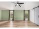 Spacious bedroom features wood-look floors, a ceiling fan, and green accent walls at 19333 N 68Th Ave, Glendale, AZ 85308