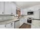 White kitchen with stainless steel appliances and stone countertops at 19333 N 68Th Ave, Glendale, AZ 85308