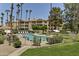 Community pool with lounge chairs and umbrellas is surrounded by lush landscaping at 19400 N Westbrook Pkwy # 320, Peoria, AZ 85382