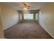 A bedroom features a ceiling fan, carpeted floor and large window that provides natural lighting at 2010 E Indigo Dr, Chandler, AZ 85286