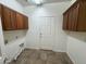 A functional laundry room boasts built-in cabinets and easy access to the home's exterior at 2010 E Indigo Dr, Chandler, AZ 85286