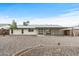 Wide backyard view with a covered patio, gravel, and mature tree at 20210 N 124Th Dr, Sun City West, AZ 85375