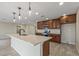 Bright kitchen with dark wood cabinets, stainless appliances, and a large central island with quartz countertops at 20210 N 124Th Dr, Sun City West, AZ 85375