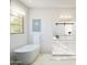 Bright bathroom featuring a freestanding tub, a sliding door mirror and natural lighting at 2024 N Woodburne Pl, Chandler, AZ 85224