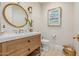 Stylish half bathroom featuring a modern vanity, decorative mirror, and patterned tile floor at 20406 E Sunset Ct, Queen Creek, AZ 85142