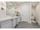 Chic powder room with gray vanity, a framed mirror, and stylish sconce lighting at 20406 E Sunset Ct, Queen Creek, AZ 85142