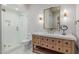 Elegant bathroom with walk-in shower, light wood vanity, and unique mirror and sconces at 20406 E Sunset Ct, Queen Creek, AZ 85142