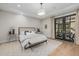 Bright bedroom with tray ceiling, hardwood floors, french doors, and a bench seat at 20406 E Sunset Ct, Queen Creek, AZ 85142