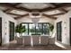 Dining room featuring high ceilings with wood beam design, a chandelier and leafy potted trees at 20406 E Sunset Ct, Queen Creek, AZ 85142