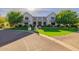 Handsome light-colored brick home with meticulous landscaping and a circular driveway, showcasing elegance and curb appeal at 20406 E Sunset Ct, Queen Creek, AZ 85142