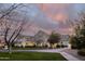 Dramatic shot of a light-colored brick home at sunset with lovely landscaping and walkway at 20406 E Sunset Ct, Queen Creek, AZ 85142