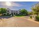 Imposing light-colored brick home with a sprawling lawn, mature trees, and circular driveway, providing an air of sophistication at 20406 E Sunset Ct, Queen Creek, AZ 85142