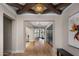 Inviting foyer with wood floors, beamed ceiling, statement lighting, and views to the outdoors at 20406 E Sunset Ct, Queen Creek, AZ 85142