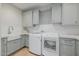 Well-lit laundry room offers shaker cabinets, quartz counters, white subway tile backsplash, and modern appliances at 20406 E Sunset Ct, Queen Creek, AZ 85142