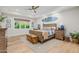 Comfortable main bedroom with ceiling fan, light wood floors and a surfboard hanging over the bed at 20406 E Sunset Ct, Queen Creek, AZ 85142