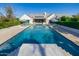 Full pool view framed by manicured greenery and striped umbrellas, offering a serene retreat at 20406 E Sunset Ct, Queen Creek, AZ 85142