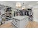 Expansive walk-in closet featuring custom shelving, an island with marble countertop, and pendant lighting at 20406 E Sunset Ct, Queen Creek, AZ 85142