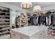 A well-organized walk-in closet offers ample storage with a marble-top island at 20406 E Sunset Ct, Queen Creek, AZ 85142