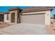 Single-story home with desert landscaping, a stone-accented entryway, and an attached two-car garage at 20660 N Confetti Ct, Maricopa, AZ 85138