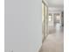 Bright hallway with tile flooring leading to a white door and a glimpse of a kitchen at 20660 N Confetti Ct, Maricopa, AZ 85138