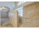 This bathroom features a glass enclosed shower, window, and neutral tile at 22139 N Van Loo Dr, Maricopa, AZ 85138