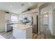 Open kitchen with stainless steel appliances, white cabinetry, center island, and hardwood flooring at 22139 N Van Loo Dr, Maricopa, AZ 85138