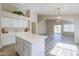 Large open kitchen features white cabinets, a center island, wood floors, and views of the living area at 22139 N Van Loo Dr, Maricopa, AZ 85138