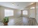 Spacious living room with wood-look floors, two large windows, and a view of the home's entryway at 22139 N Van Loo Dr, Maricopa, AZ 85138