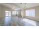 Bright living room features wood-look tile floors, ceiling fan, and sliding glass door access to the backyard at 22139 N Van Loo Dr, Maricopa, AZ 85138